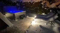 a hot tub with blue lights on a snow covered yard at Au-Doux-Altic chalet romantique avec JACUZZI ET SAUNA in Métabief