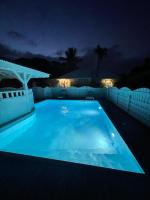 - une grande piscine bleue la nuit dans l&#39;établissement Bungalow confort avec piscine, à Saint-François