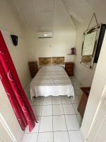 - une chambre avec un lit et des rideaux rouges dans l&#39;établissement Bungalow confort avec piscine, à Saint-François