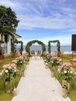 a wedding aisle with chairs and an arch with flowers at 71% Diving Resort in Dumaguete