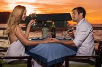a man and woman sitting at a table with wine glasses at Papua Paradise Eco Resort in Pulau Birie