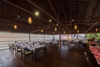 a dining room with tables and chairs in a building at Papua Paradise Eco Resort in Pulau Birie