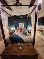 a bedroom with a canopy bed with a wooden table at A l&#39;Orée des pins - Gite indépendant avec baignoire balnéo et Home Cinéma en sup - Voir info de l&#39;hôte in Cuges-les-Pins