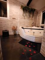 a bathroom with a white tub and a sink at A l&#39;Orée des pins - Gite indépendant avec baignoire balnéo et Home Cinéma en sup - Voir info de l&#39;hôte in Cuges-les-Pins