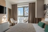 a hotel room with a large bed and a window at Lagrange Apart&#39;Hôtel Antibes Olympie in Antibes