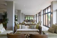 een woonkamer met banken, een tafel en ramen bij San Lameer Villa 3303 - 2 Bedroom Classic - 4 pax - San Lameer Rental Agency in Southbroom