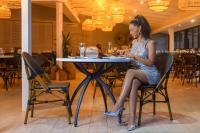 een vrouw die aan een tafel in een restaurant zit bij San Lameer Villa 3303 - 2 Bedroom Classic - 4 pax - San Lameer Rental Agency in Southbroom