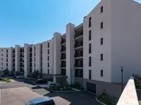 a row of apartment buildings in a parking lot at Apartment Stanatura-4 by Interhome in Porto-Vecchio