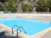 a large blue swimming pool with two metal at Apartment Eden Roc 2 by Interhome in Narbonne-Plage
