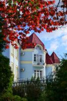 a large white house with a red roof at Pysanka Hotel in Kolomyya