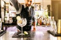 a man standing at a bar making a drink at Vignette Collection Yours Truly DC by IHG in Washington