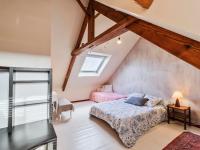 a attic bedroom with a bed and a window at Holiday Home Les Roses by Interhome in Yffiniac