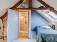 a small attic bedroom with a bed and a shower at Holiday Home Les Roses by Interhome in Yffiniac