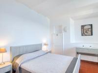 a white bedroom with a bed and two lamps at Apartment la Rainette by Interhome in La Madrague