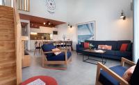 Il comprend un salon avec un canapé bleu et une cuisine. dans l&#39;établissement Pierre &amp; Vacances Premium Les Villas d&#39;Olonne, à Les Sables-dʼOlonne