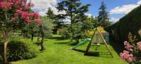 a hammock in a garden with trees and flowers at La Villa Moursoise 4 Etoiles in Mours-Saint-EusÃ¨be