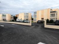 a parking lot with cars parked in front of buildings at valras appartement T2 proche mer et port in Valras-Plage