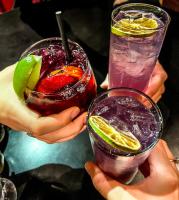 a group of hands holding two glasses of cocktails at Lake Louise Inn in Lake Louise