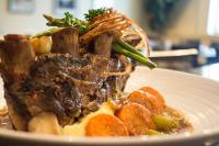 a plate of food with meat and vegetables on it at Lake Louise Inn in Lake Louise