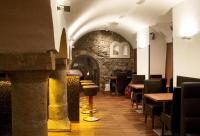 a restaurant with tables and chairs and a stone wall at Boutique Hotel Nautilus in Tábor