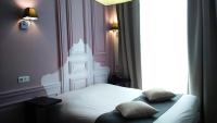 a bedroom with a white bed with two pillows on it at Odalys City Montpellier Les Occitanes in Montpellier