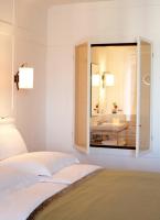 a bedroom with a mirror on the wall at Louis Hotel in Munich