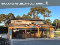 a building with glass doors in a parking lot at Le Cocon Cap Forêt in Lège-Cap-Ferret