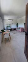 Una sala de estar con una mesa y un sofá rosa. en Complejo Junin Dpto Planta Alta, en Formosa