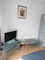a living room with a tv and a glass table at Logies Lily in Oudenburg