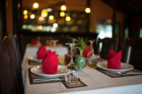 une table avec des assiettes et des coussins rouges dessus dans l'établissement Kouprey Hotel, à Siem Reap