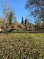 a park with a bench in a field with a lake at Hôtel L&#39;ile Du Saussay in Itteville