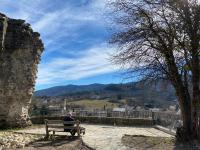 a man sitting on a bench in front of a castle at La Peyreyre in Jaujac