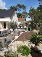 a patio with couches and chairs in front of a house at Belle de Dune in La Baule