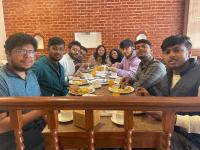 a group of people sitting around a table eating food at Madhuban Hotel in Kathmandu