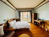 a bedroom with a bed and a desk and a window at 見晴花園山莊Sunshine Villa in Ren&#39;ai