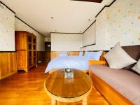 a bedroom with a bed and a table and a couch at 見晴花園山莊Sunshine Villa in Ren&#39;ai