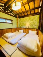 two beds in a room with a window at 見晴花園山莊Sunshine Villa in Ren&#39;ai