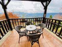 a table and chairs on a balcony with a view at 見晴花園山莊Sunshine Villa in Ren&#39;ai