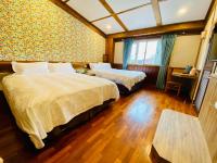 a hotel room with two beds and a window at 見晴花園山莊Sunshine Villa in Ren&#39;ai