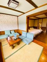 a living room with a bed and a couch and a table at 見晴花園山莊Sunshine Villa in Ren&#39;ai