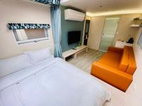 a bedroom with a white bed and an orange chair at 見晴花園山莊Sunshine Villa in Ren&#39;ai