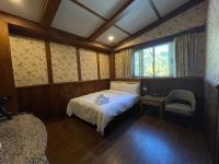 a bedroom with a bed and a chair and a window at 見晴花園山莊Sunshine Villa in Ren&#39;ai