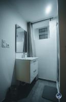 a bathroom with a white sink and a mirror at Appartement neuf et moderne dans le centre ville in Bagnols-sur-Cèze