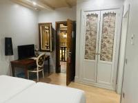a bedroom with a bed and a desk and a door at Sacristia de Santa Ana in Seville