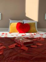 a bed with a red heart and a box of chocolate at Hôtel L&#39;ile Du Saussay in Itteville