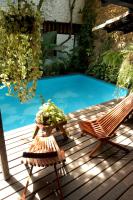 a deck with two chairs and a swimming pool at Pousada Arte Urquijo in Paraty