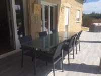 a glass table and chairs on a patio at Villa Emma 10 &#47; 12 personnes in Grignan