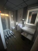 a bathroom with a sink and a toilet and a mirror at Hotel Des Lices in Rennes