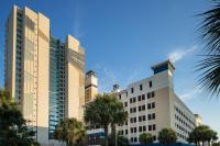 ein Gebäude mit Palmen davor in der Unterkunft Courtyard by Marriott Myrtle Beach Oceanfront in Myrtle Beach