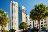 ein hohes Gebäude mit Palmen davor in der Unterkunft Courtyard by Marriott Myrtle Beach Oceanfront in Myrtle Beach